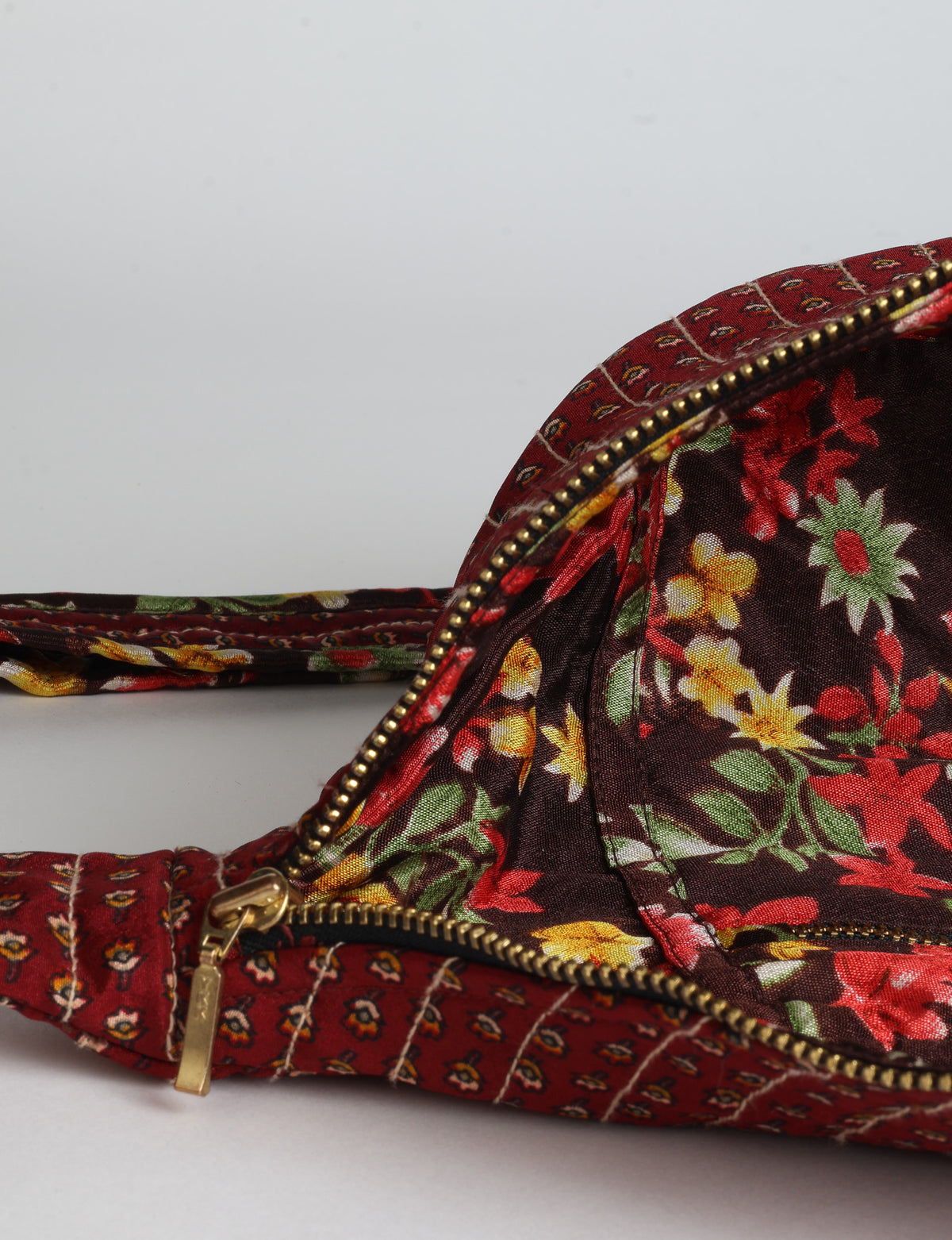 Quilted large shoulder bag with a curved silhouette, adjustable strap and zip-top closure.