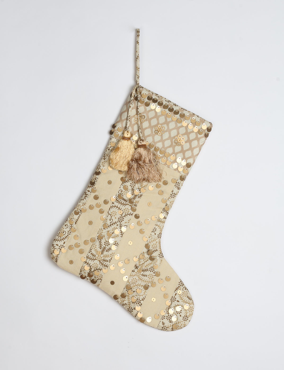 Christmas stocking with beige and brown vertical stripes, floral pattern, gold sequins, and two tassels on hanging loop