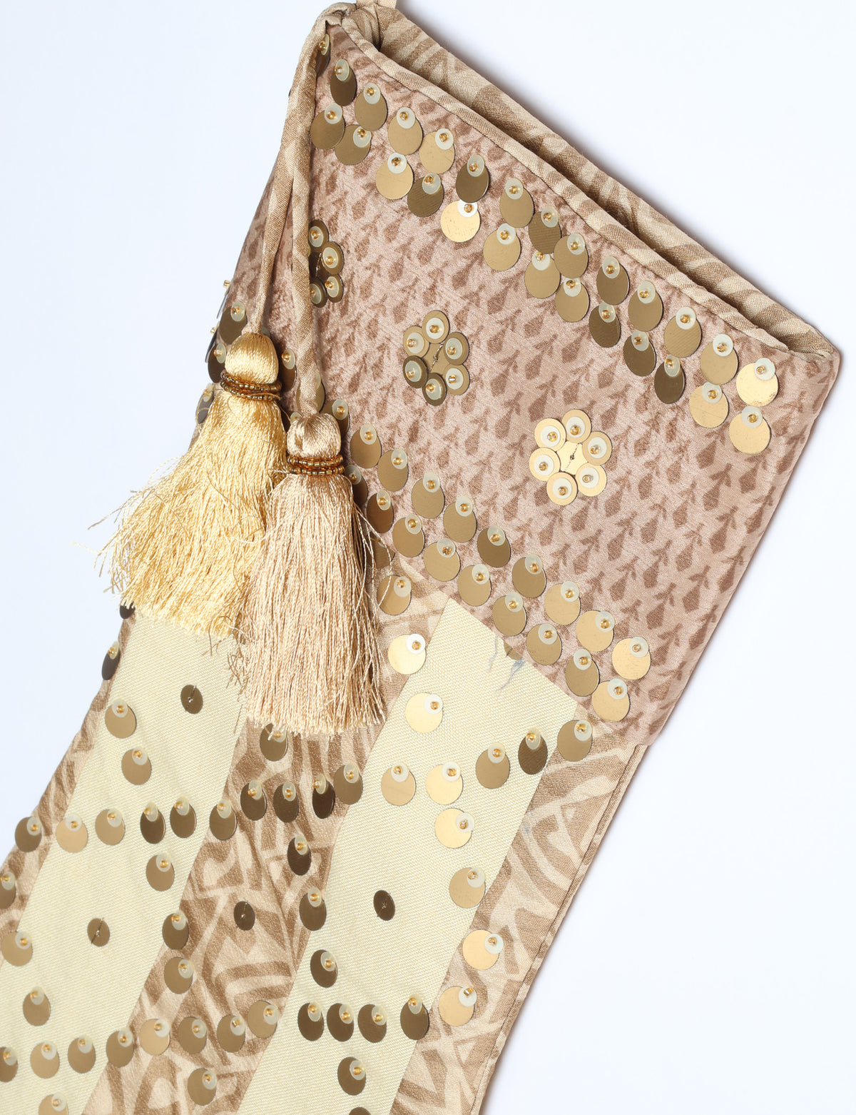 Christmas stocking with beige and brown floral and stripe pattern, gold sequins, and two beige tassels on hanging loop