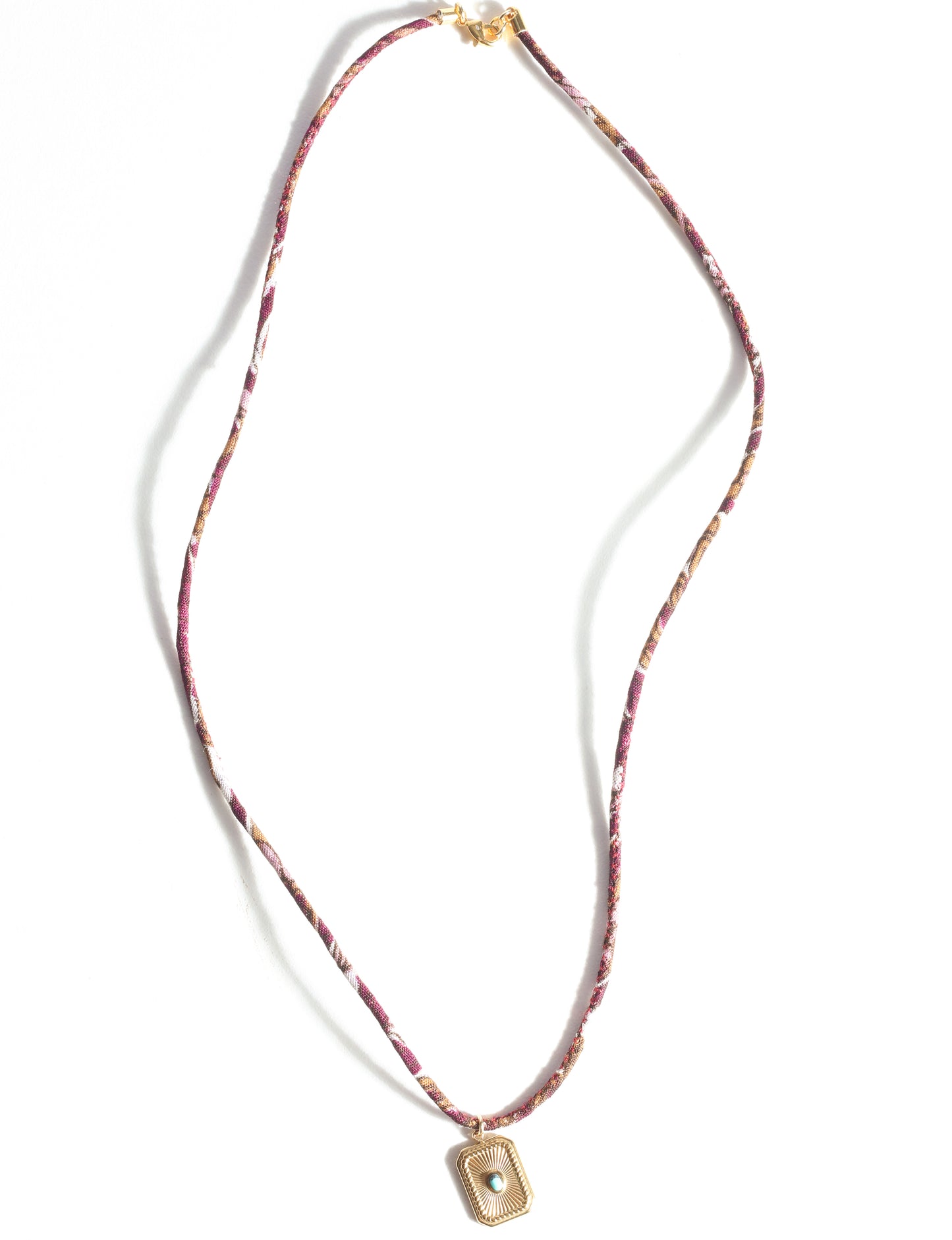 Adjustable cord necklace with gold-plated metal pendant inspired by upcycled women’s clothing, sustainable women’s clothing, eco friendly fashion, recycled sustainable fashion, carbon neutral fashion, and environment friendly clothing principles.