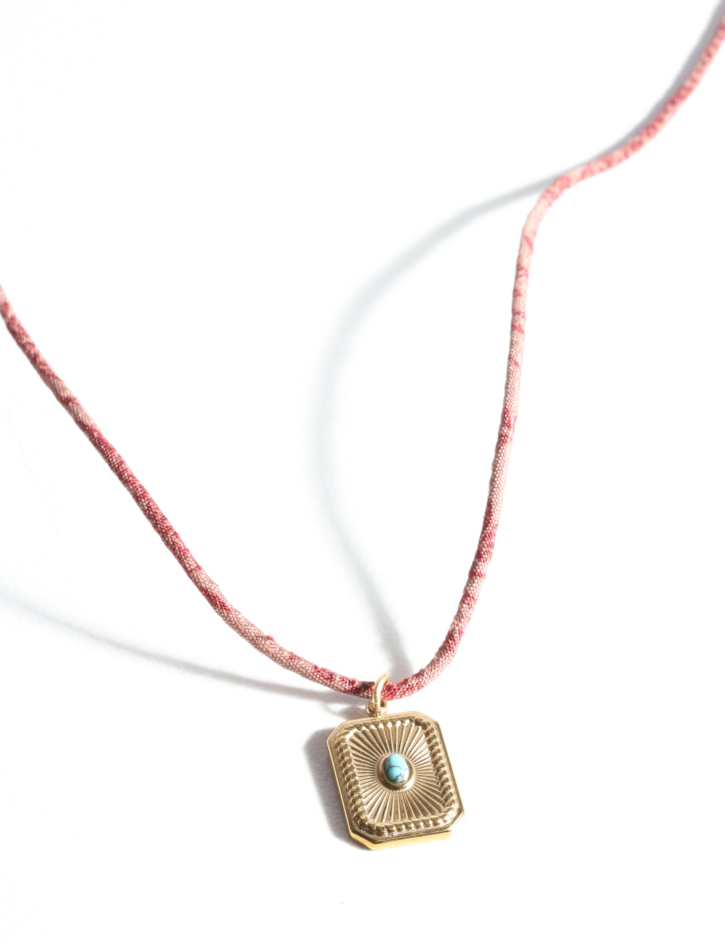 Adjustable cord necklace with gold-plated metal pendant inspired by upcycled women’s clothing, sustainable women’s clothing, eco friendly fashion, recycled sustainable fashion, carbon neutral fashion, and environment friendly clothing principles.