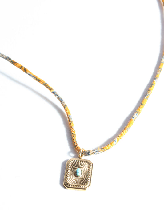 Adjustable cord necklace with gold-plated metal pendant inspired by upcycled women’s clothing, sustainable women’s clothing, eco friendly fashion, recycled sustainable fashion, carbon neutral fashion, and environment friendly clothing principles.