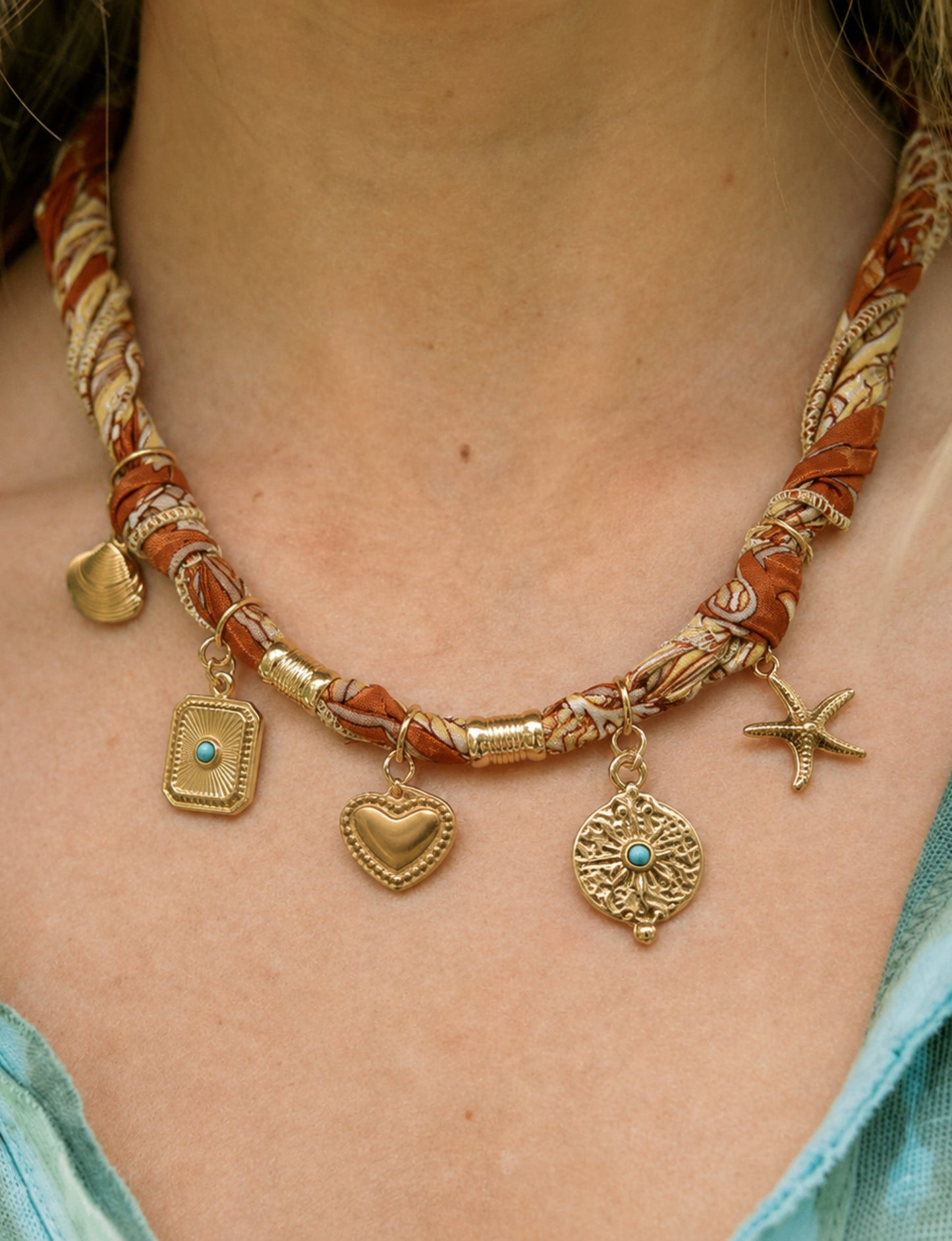 Bandana necklace with gold-plated charms, adjustable tie-back design, stainless steel hardware, handmade statement necklace, sustainable fashion accessory.
