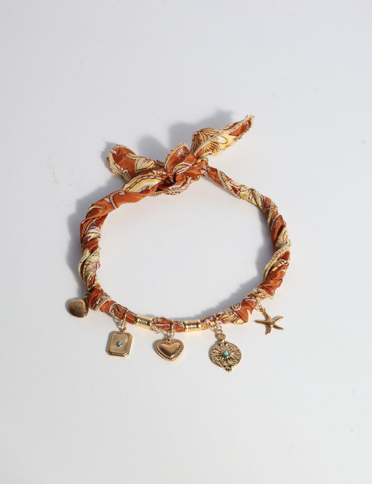 Bandana necklace with gold-plated charms, adjustable tie-back design, stainless steel hardware, handmade statement necklace, sustainable fashion accessory.