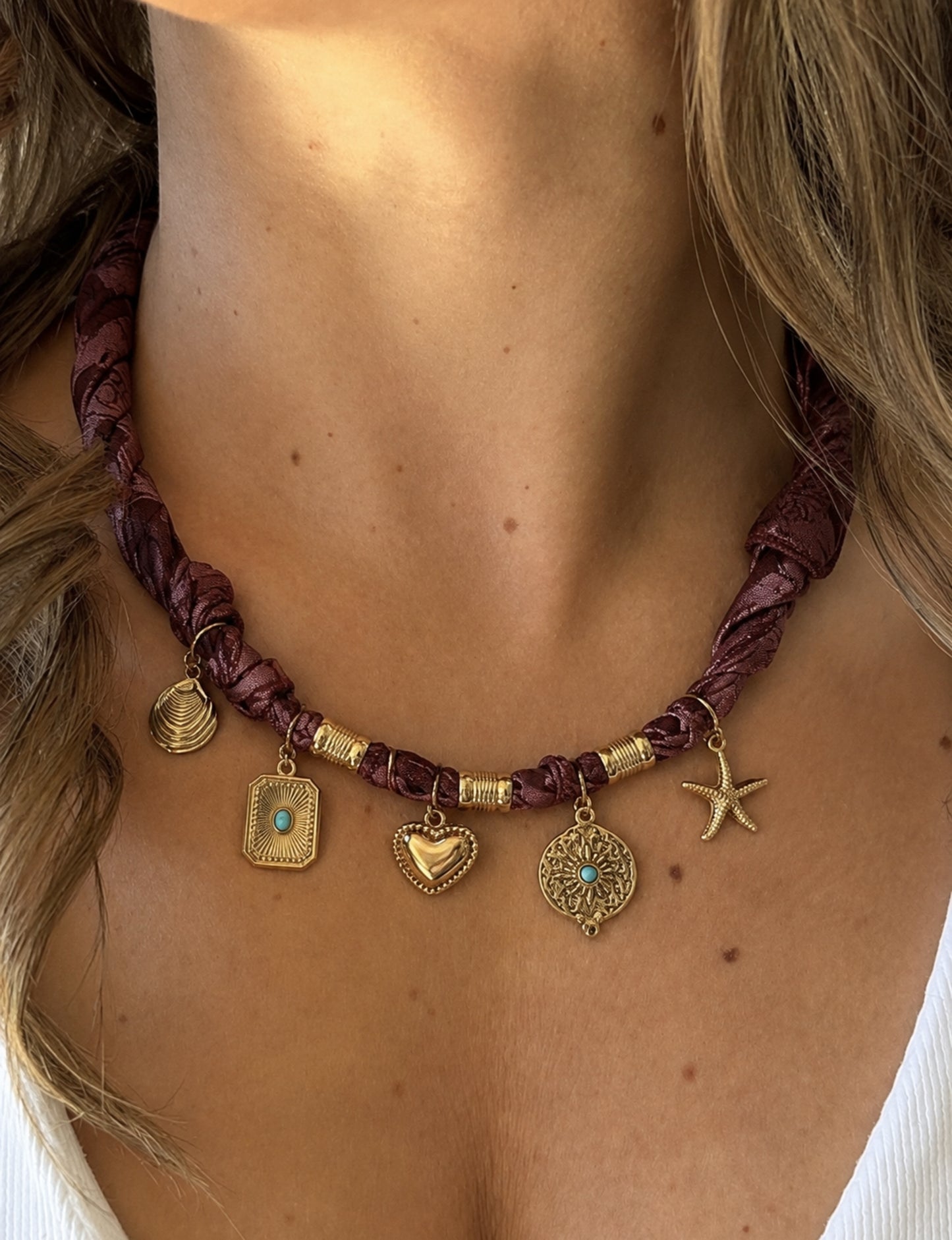 Bandana necklace with gold-plated charms, adjustable tie-back design, stainless steel hardware, handmade statement necklace, sustainable fashion accessory.