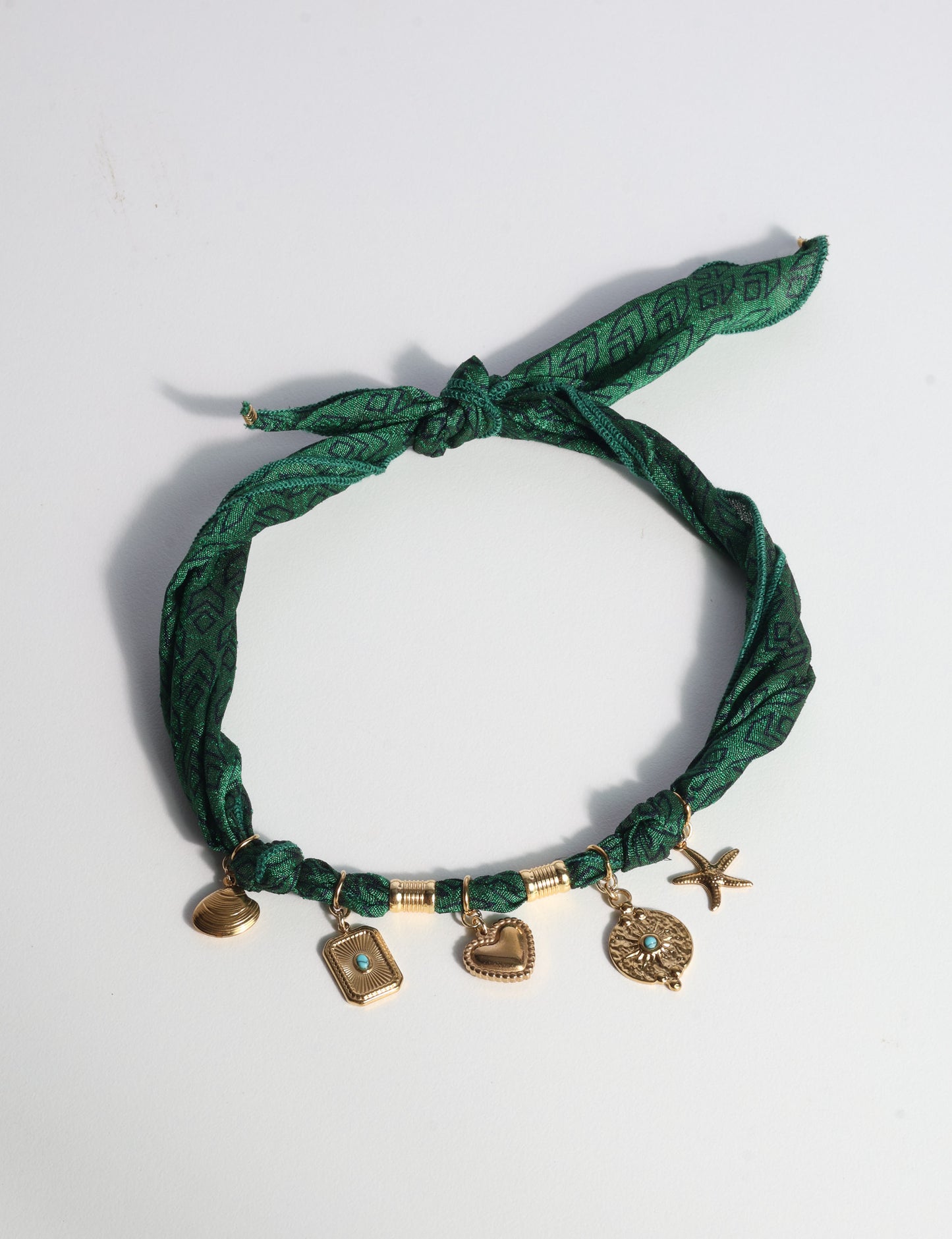 Bandana necklace with gold-plated charms, adjustable tie-back design, stainless steel hardware, handmade statement necklace, sustainable fashion accessory.