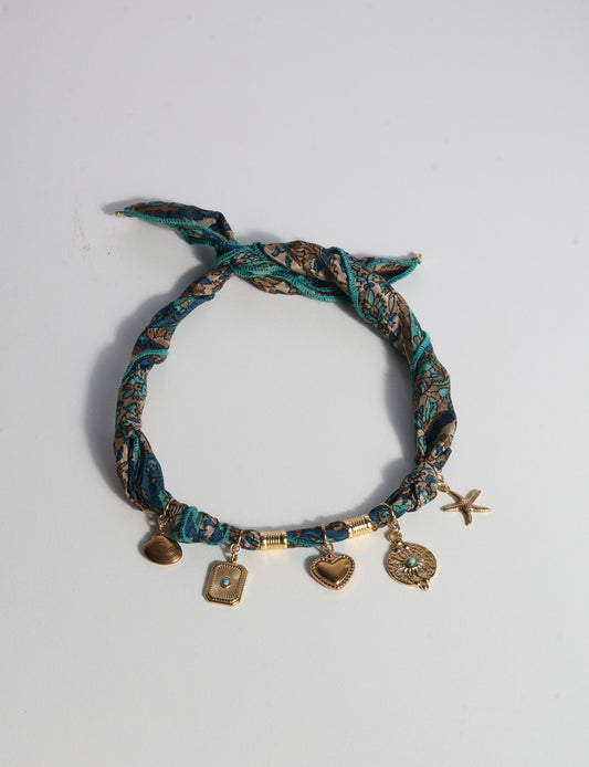 Bandana necklace with gold-plated charms, adjustable tie-back design, stainless steel hardware, handmade statement necklace, sustainable fashion accessory.