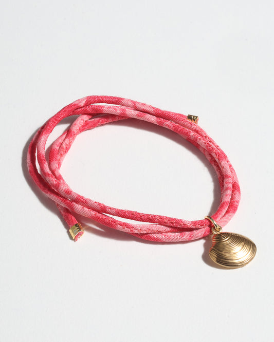 Adjustable slim cord bracelet with gold-plated stainless steel shell charm inspired by upcycled women’s clothing, sustainable women’s clothing, eco friendly clothes, recycled sustainable fashion, carbon neutral clothing, and environment friendly clothing values.