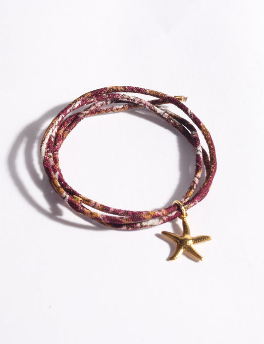 Slim adjustable cord bracelet with gold-plated stainless steel star fish charm inspired by upcycled women’s clothing, sustainable women’s clothing, eco friendly clothes, recycled sustainable fashion, carbon neutral clothing, and environment friendly clothing values.