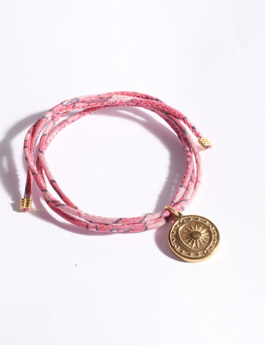 Slim adjustable cord bracelet with gold-plated stainless steel sun charm, inspired by upcycled women’s clothing, sustainable women’s clothing, eco friendly fashion, recycled sustainable fashion, carbon neutral fashion, and environment friendly clothing values.