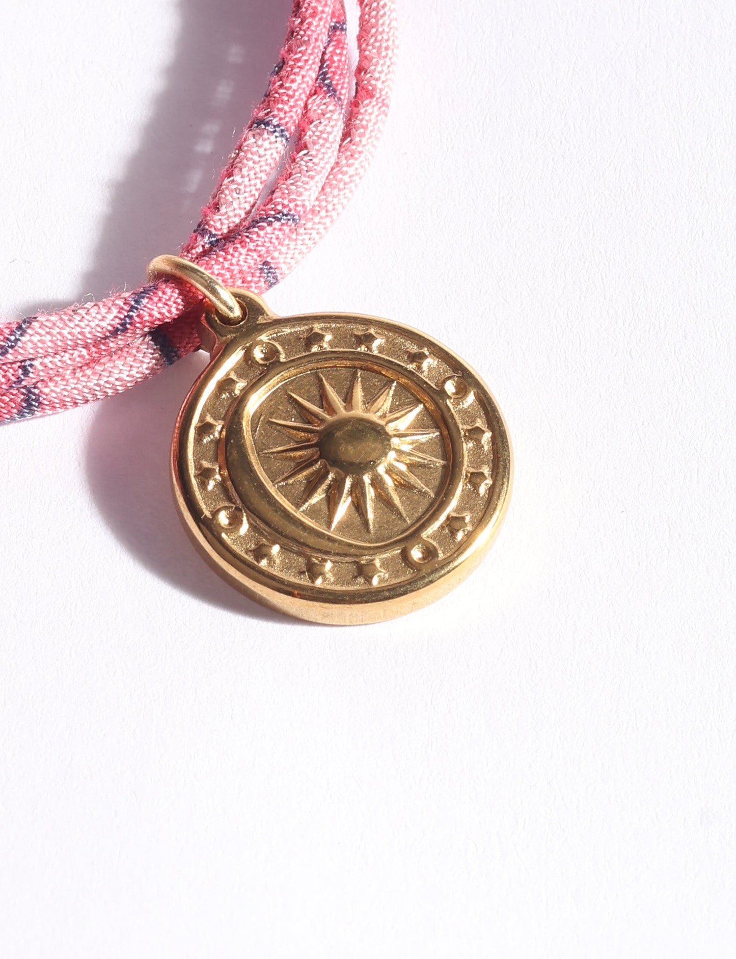 Slim adjustable cord bracelet with gold-plated stainless steel sun charm, inspired by upcycled women’s clothing, sustainable women’s clothing, eco friendly fashion, recycled sustainable fashion, carbon neutral fashion, and environment friendly clothing values.