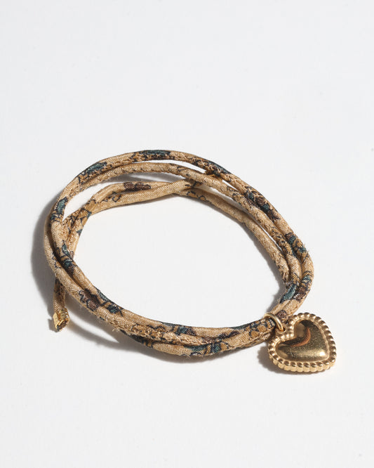 Slim adjustable cord bracelet with gold-plated stainless steel heart charm inspired by upcycled women’s clothing, sustainable women’s clothing, eco friendly fashion, recycled sustainable fashion, carbon neutral fashion, and environment friendly clothes values.