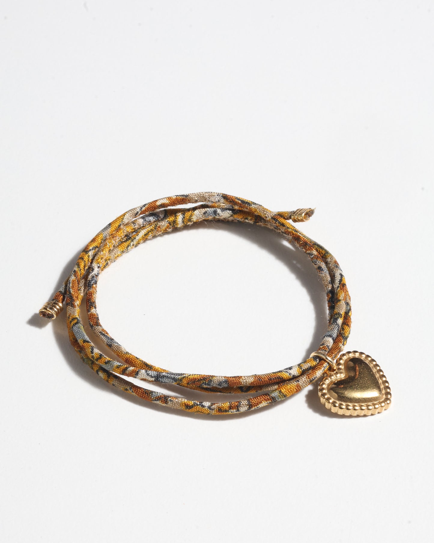 Slim adjustable cord bracelet with gold-plated stainless steel heart charm inspired by upcycled women’s clothing, sustainable women’s clothing, eco friendly fashion, recycled sustainable fashion, carbon neutral fashion, and environment friendly clothes values.