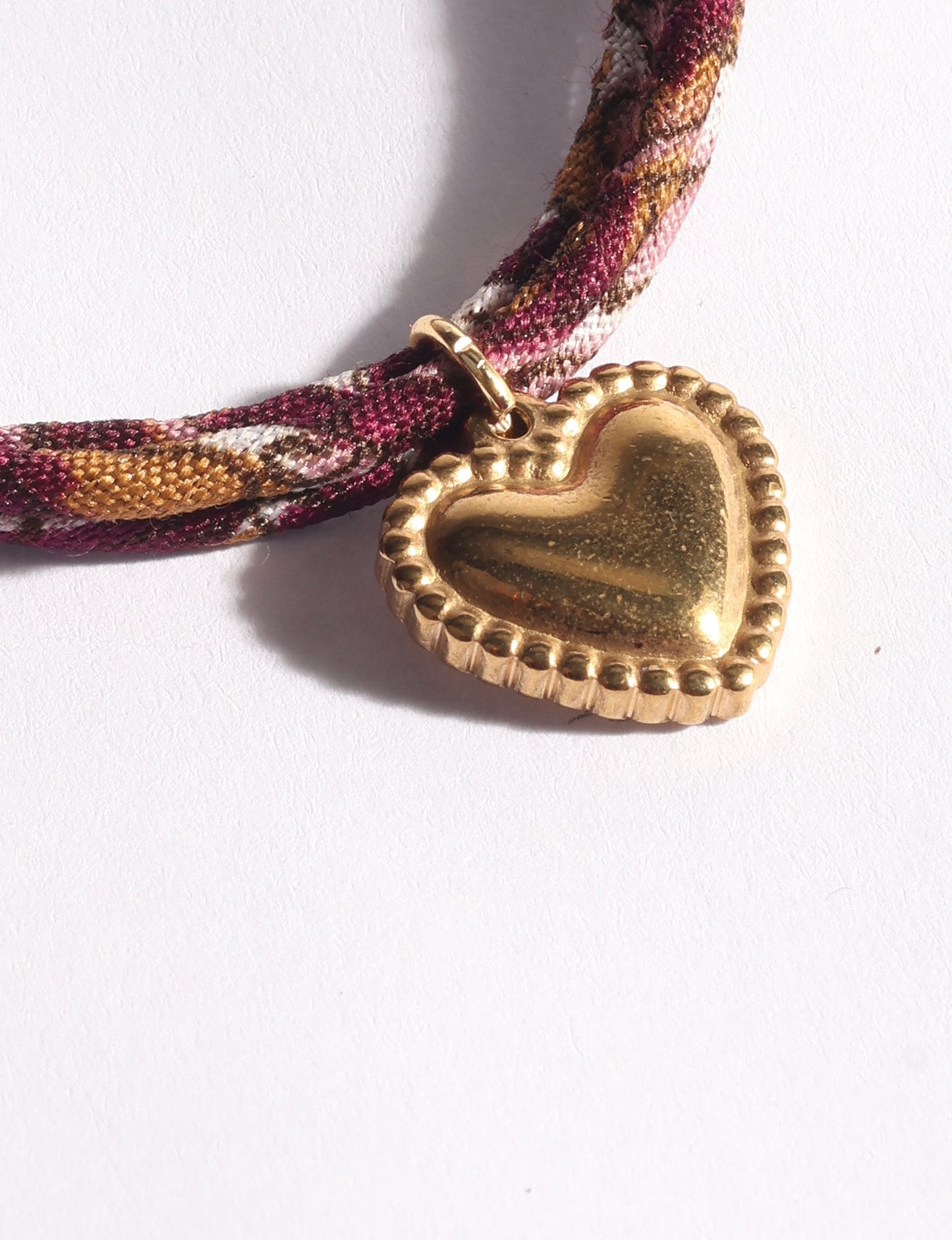 Slim adjustable cord bracelet with gold-plated stainless steel heart charm inspired by upcycled women’s clothing, sustainable women’s clothing, eco friendly fashion, recycled sustainable fashion, carbon neutral fashion, and environment friendly clothes values.