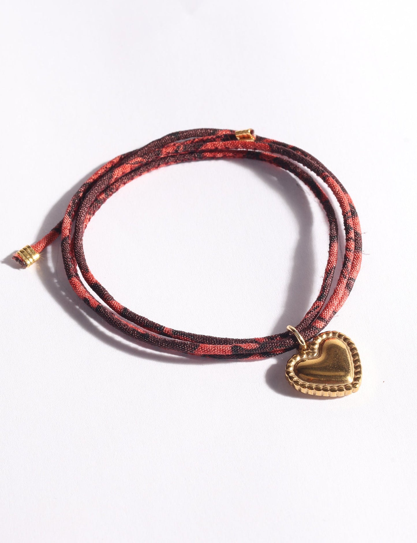Slim adjustable cord bracelet with gold-plated stainless steel heart charm inspired by upcycled women’s clothing, sustainable women’s clothing, eco friendly fashion, recycled sustainable fashion, carbon neutral fashion, and environment friendly clothes values.
