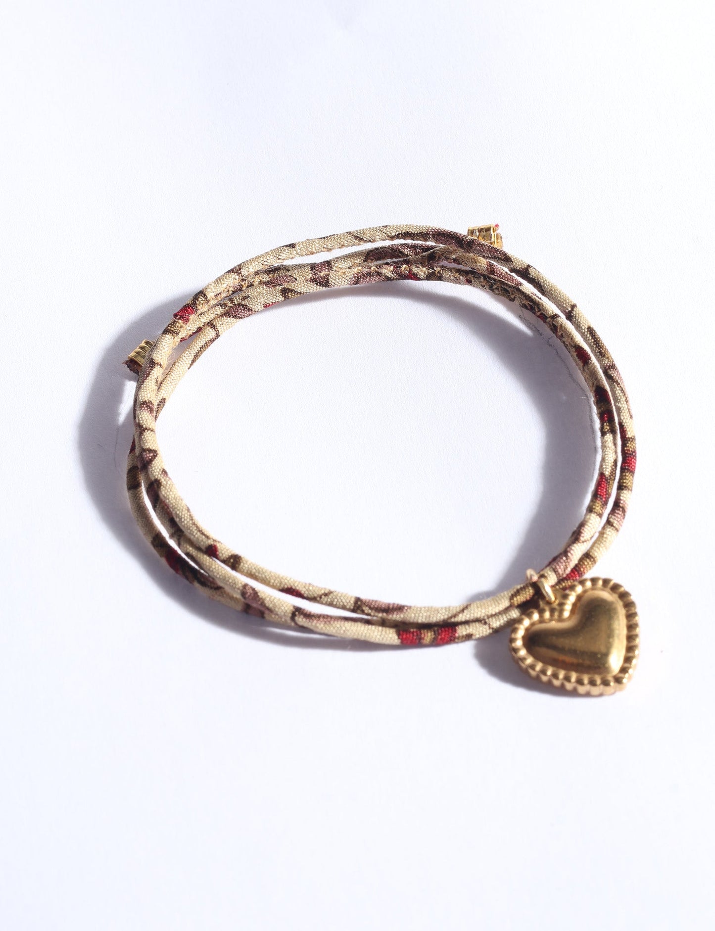 Slim adjustable cord bracelet with gold-plated stainless steel heart charm inspired by upcycled women’s clothing, sustainable women’s clothing, eco friendly fashion, recycled sustainable fashion, carbon neutral fashion, and environment friendly clothes values.