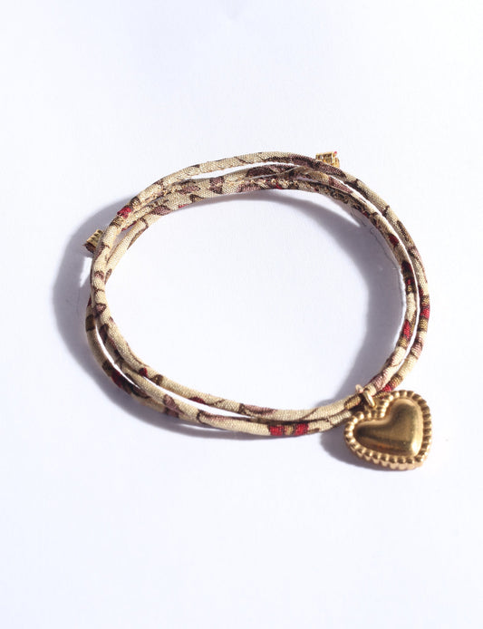 Slim adjustable cord bracelet with gold-plated stainless steel heart charm inspired by upcycled women’s clothing, sustainable women’s clothing, eco friendly fashion, recycled sustainable fashion, carbon neutral fashion, and environment friendly clothes values.