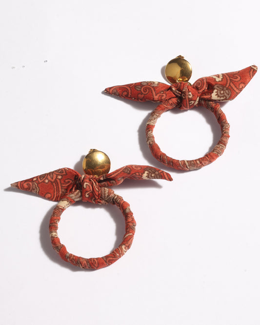 Drop earrings with bow detail and circular ring inspired by upcycled women’s clothing, sustainable women’s clothing, eco friendly clothes, recycled sustainable fashion, carbon neutral clothing, and environment friendly clothing values.