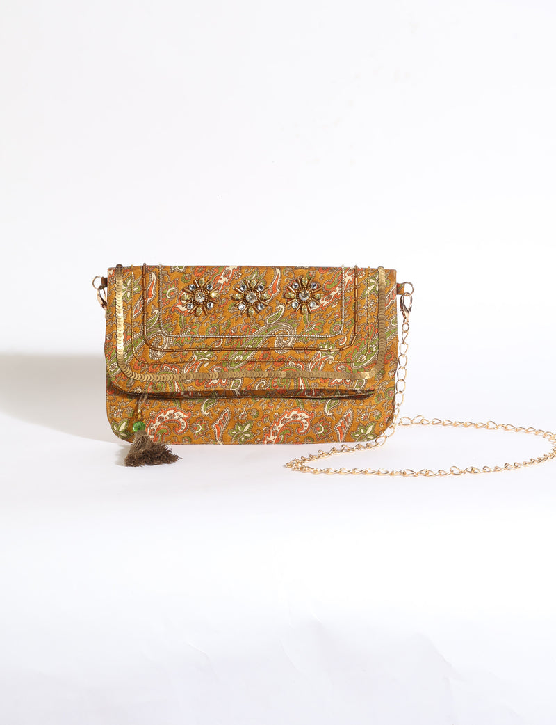 Embroidered evening bag with embellished fold-over flap, tassel detail, and detachable metal chain strap.