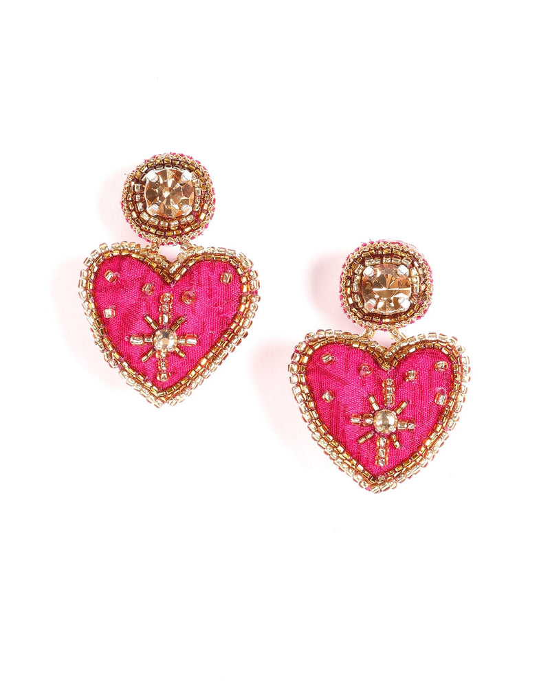 Pink fabric heart drop earrings with gold bead trim and central rhinestone embellishments, shown flat on white background