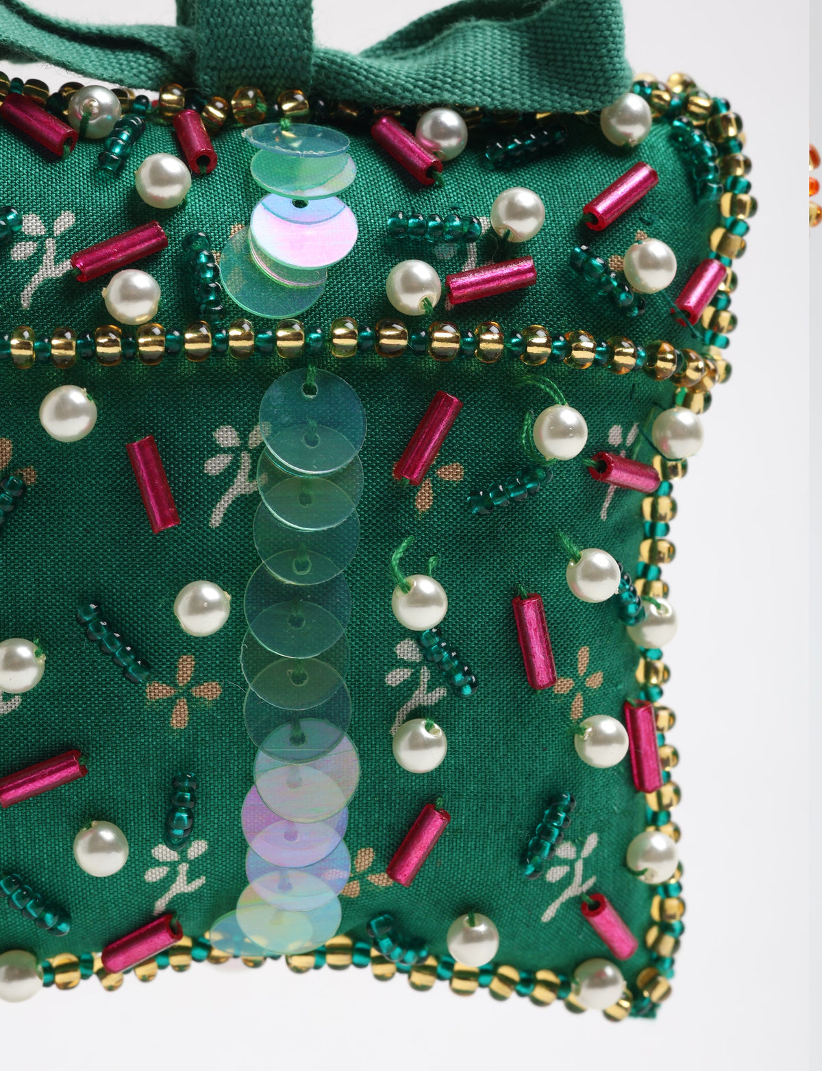 Green fabric gift ornament decorated with pearl beads, red cylindrical beads, iridescent sequins, and gold and green seed