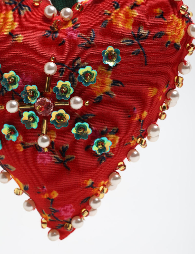 Red fabric heart ornament with yellow and pink floral print, decorated with pearl beads and blue flower-shaped sequins