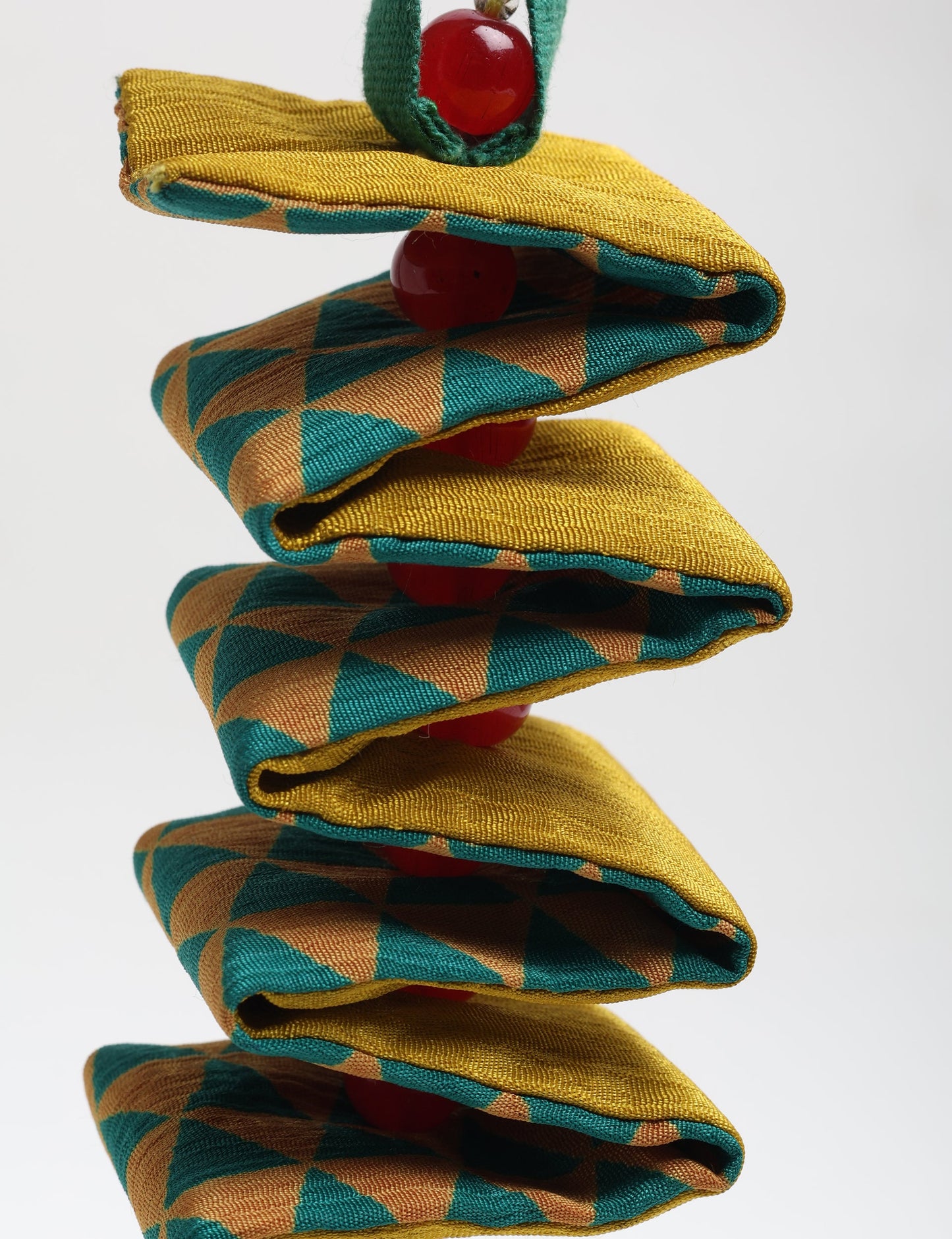 Handcrafted upcycled candy cane ornament made from recycled sari fabric and organic cotton, reflecting fair trade fashion and circular fashion principles in eco friendly, repurposed clothing craftsmanship.