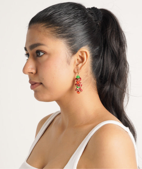 Model wearing pink and green abstract Floret dangler earring with multiple small floral elements, side profile view