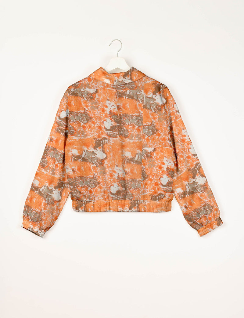 Orange and gray abstract patterned bomber jacket with elastic cuffs and waistband, shown from back on white hanger