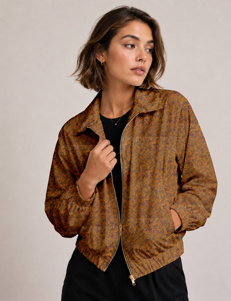 Woman wearing a yellow floral bomber jacket with front zipper, elastic cuffs, and side pockets, shown from front view