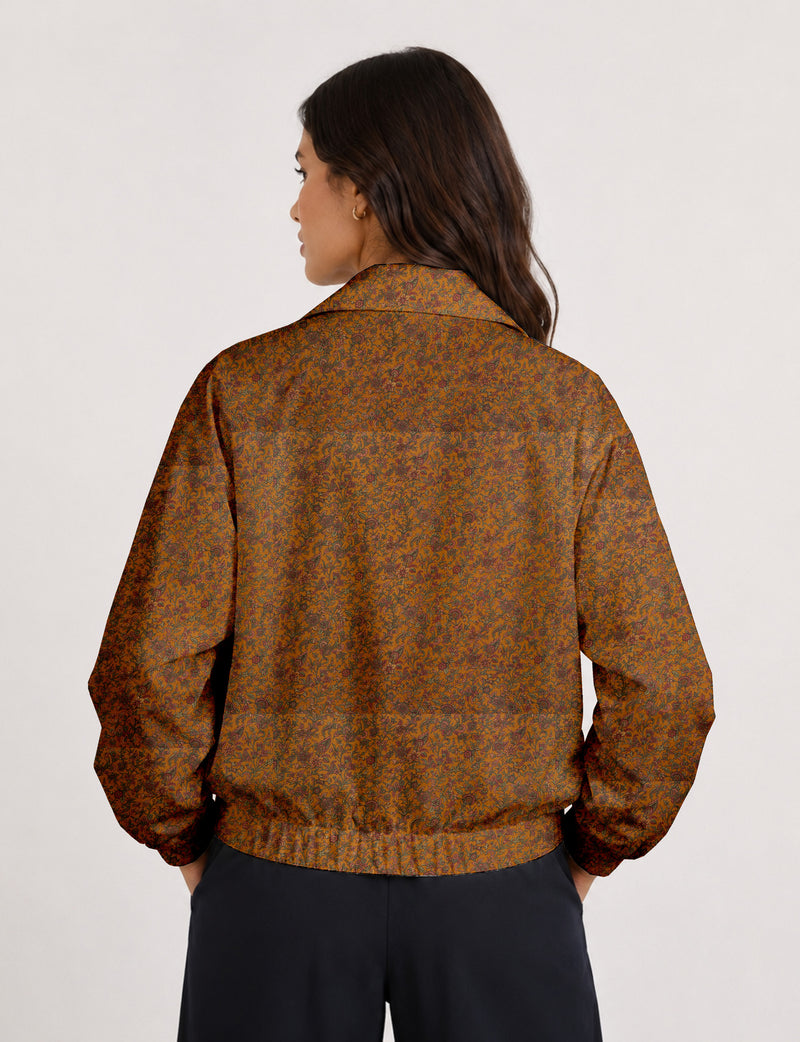 Woman wearing a yellow floral bomber jacket with front zipper, elastic cuffs, and side pockets, shown from front view