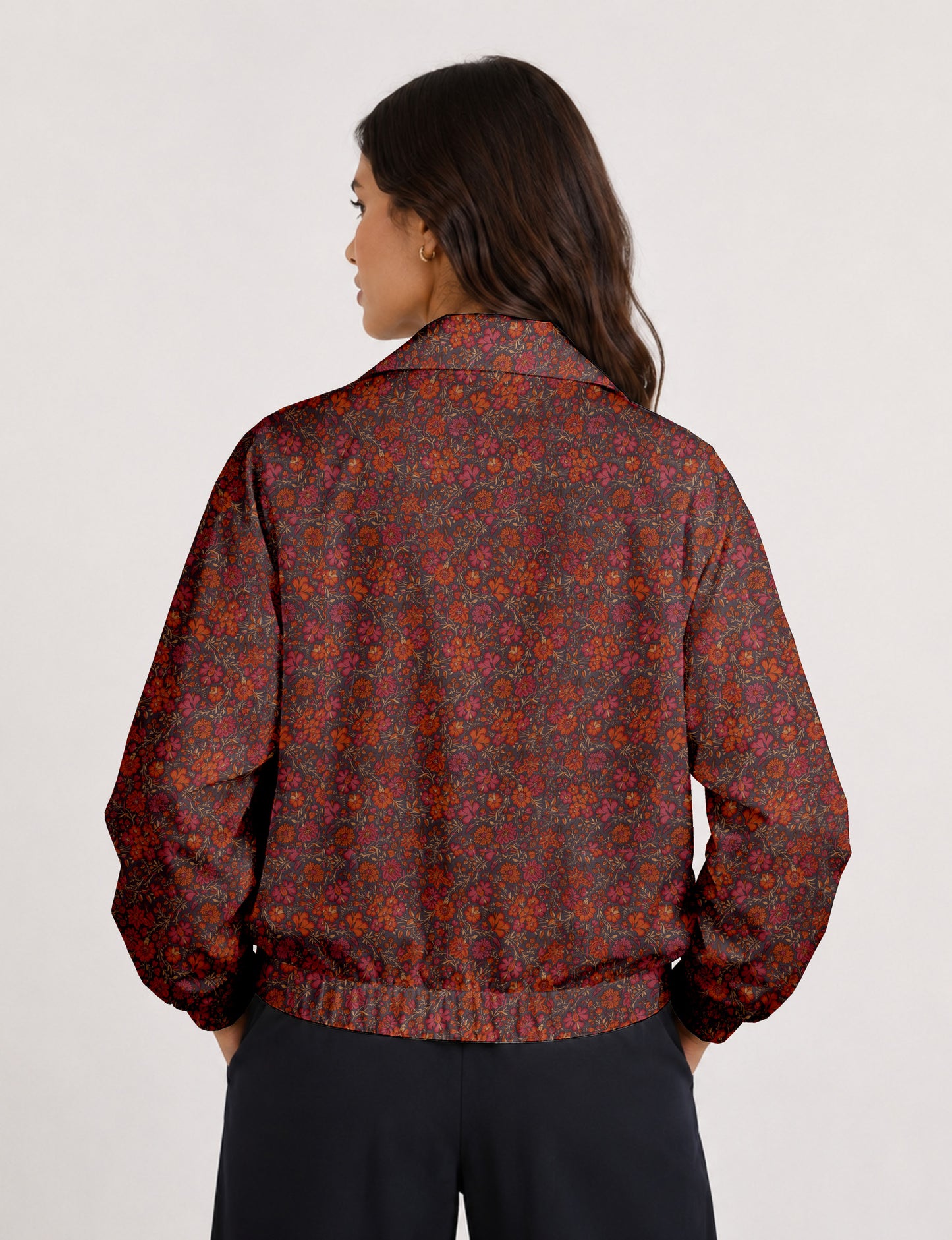 Woman wearing a yellow floral bomber jacket with front zipper, elastic cuffs, and side pockets, shown from front view