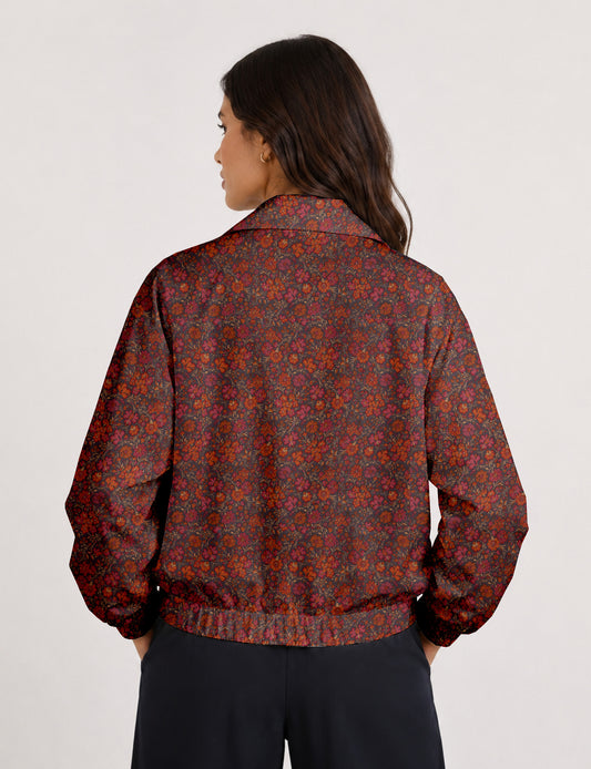 Woman wearing a yellow floral bomber jacket with front zipper, elastic cuffs, and side pockets, shown from front view
