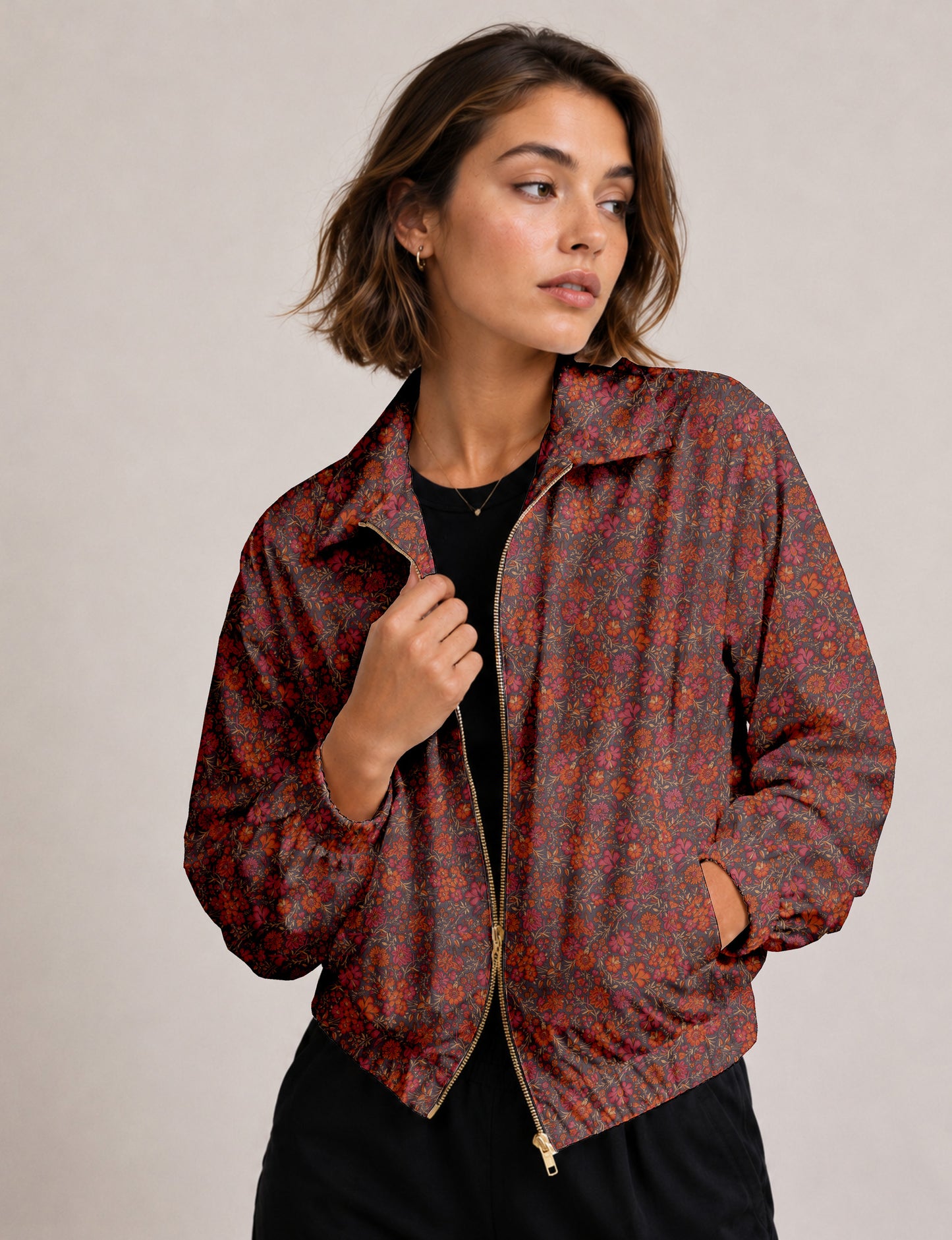 Woman wearing a yellow floral bomber jacket with front zipper, elastic cuffs, and side pockets, shown from front view