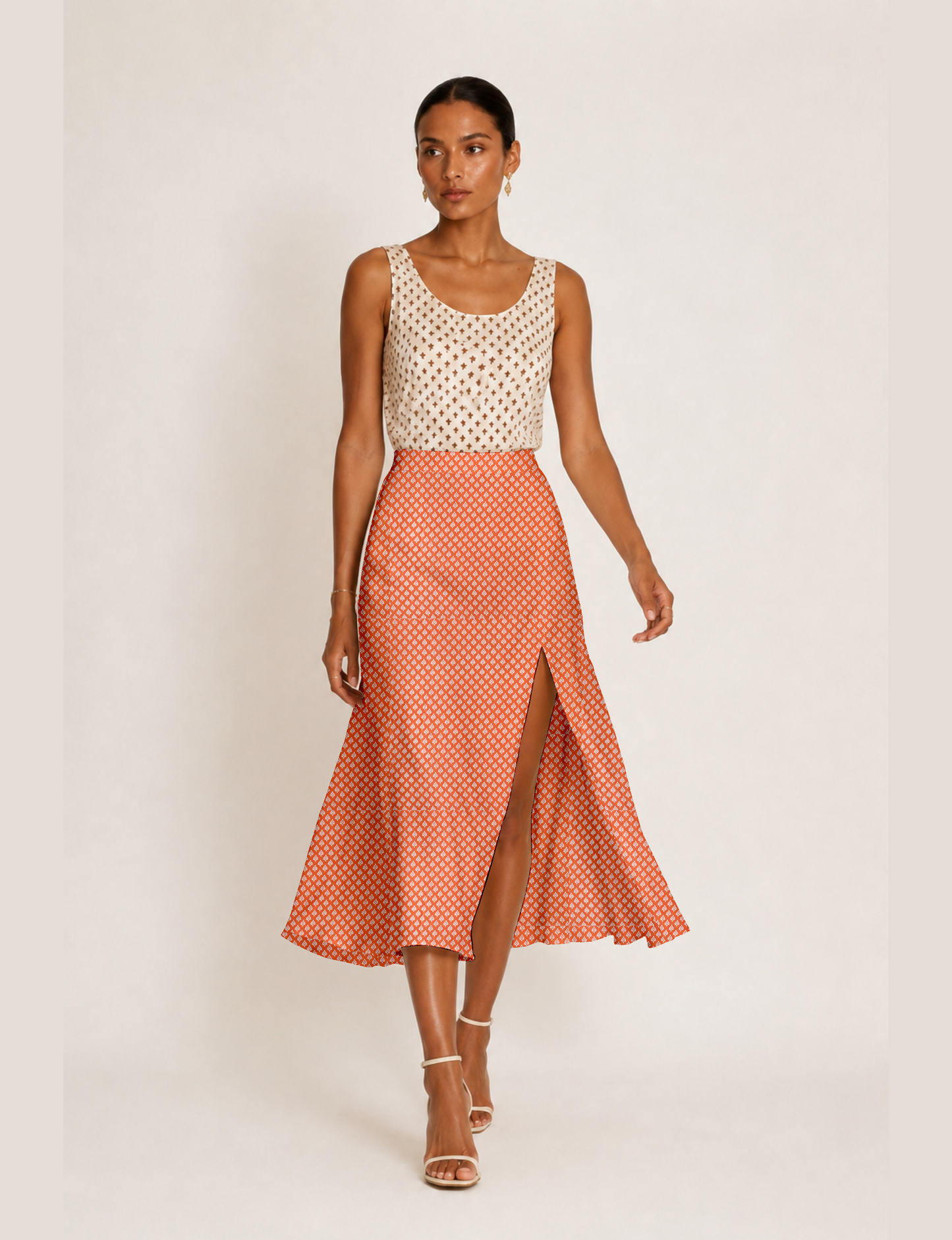 Woman wearing a yellow and black micro patterned A-line skirt with front slit, paired with beige sleeveless top and black