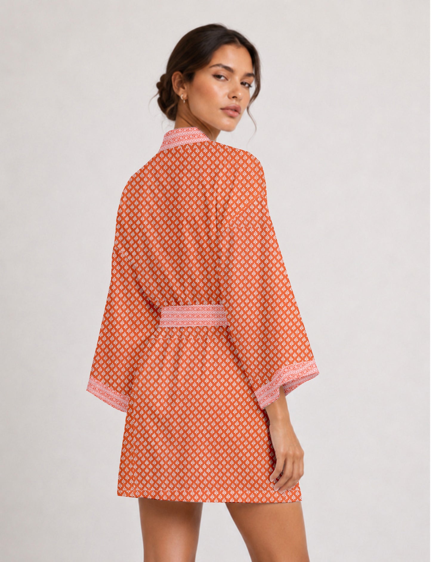 Short kimono robe with wrap front, V-neckline, wide sleeves, waist tie, and concealed skort detail.