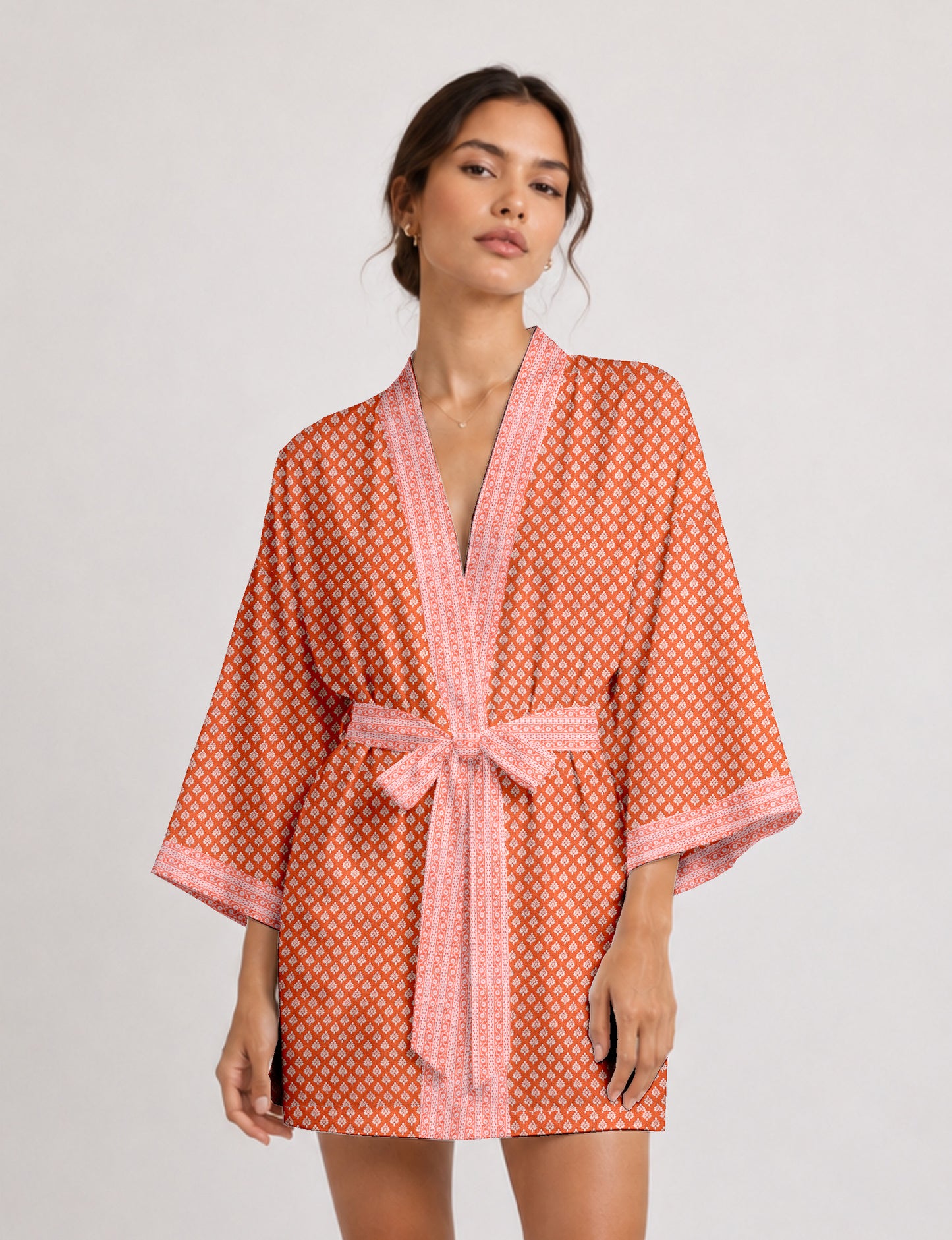 Short kimono robe with wrap front, V-neckline, wide sleeves, waist tie, and concealed skort detail.