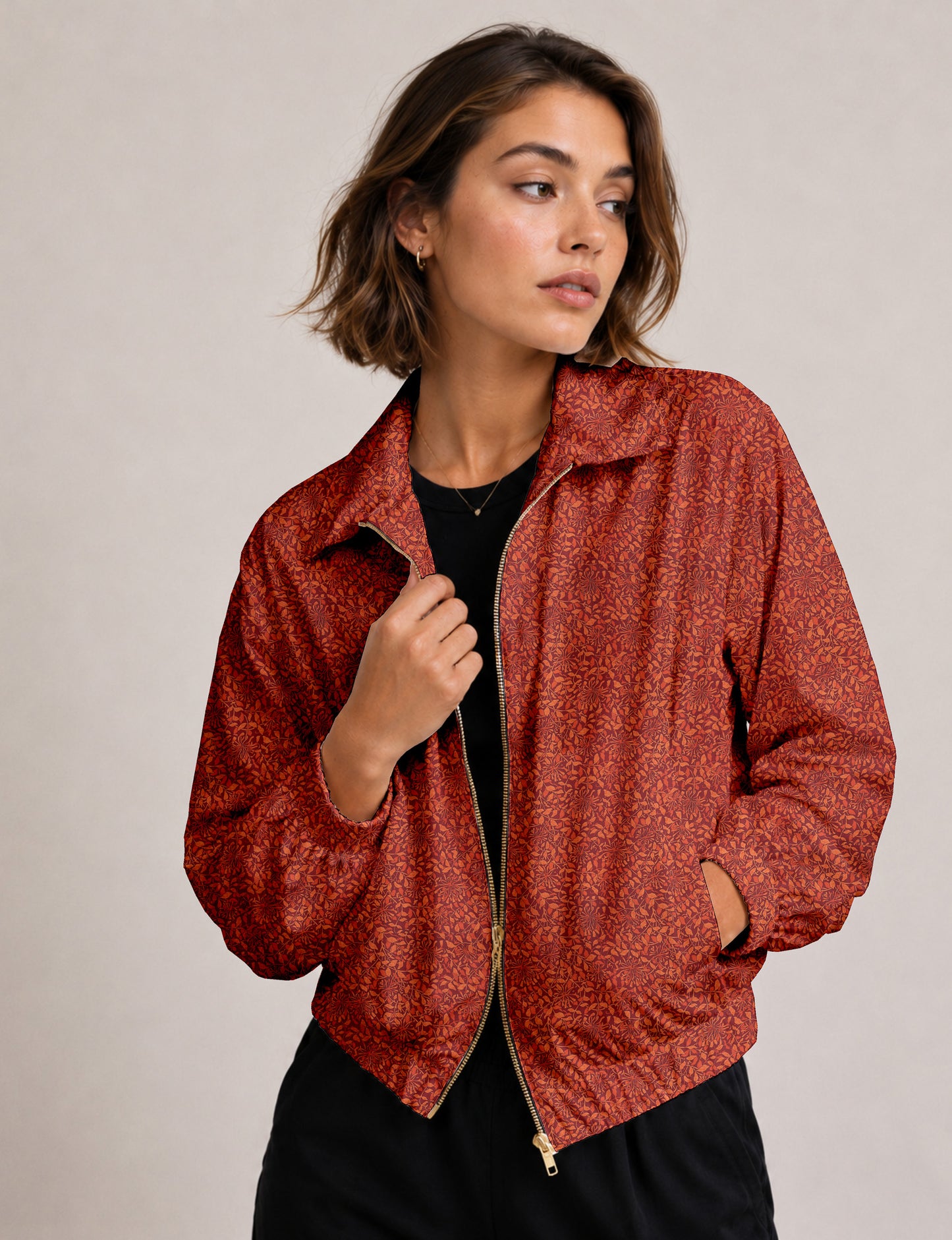 Woman wearing a yellow floral bomber jacket with front zipper, elastic cuffs, and side pockets, shown from front view