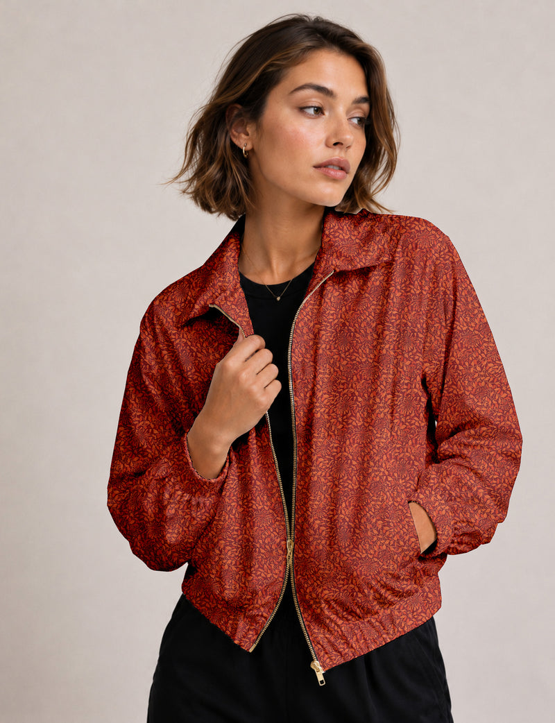 Woman wearing a yellow floral bomber jacket with front zipper, elastic cuffs, and side pockets, shown from front view