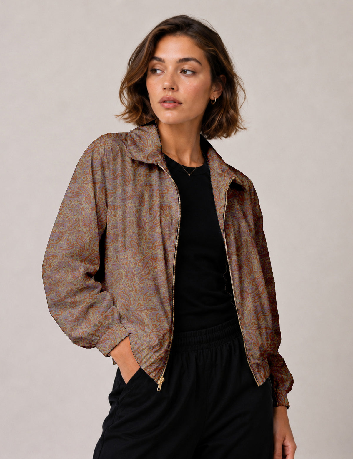 Woman wearing a yellow floral bomber jacket with front zipper, elastic cuffs, and side pockets, shown from front view