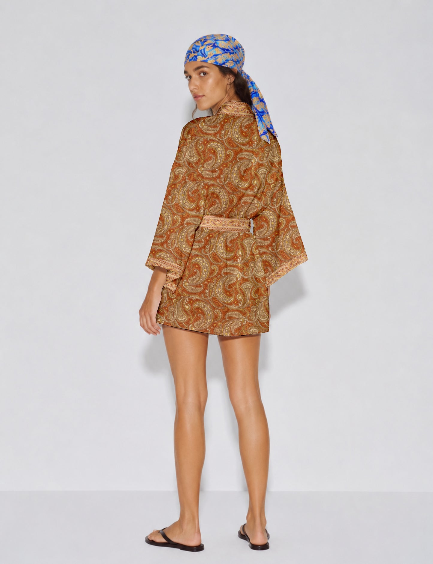 Short kimono robe with wrap front, V-neckline, wide sleeves, waist tie, and concealed skort detail.