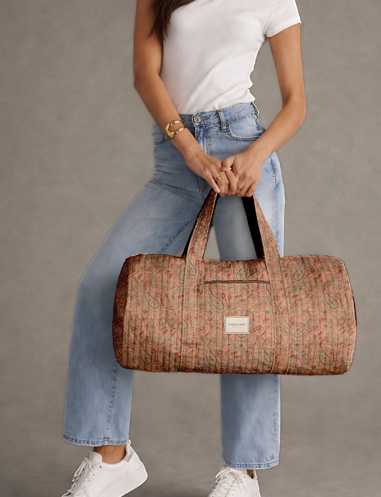 Beige quilted bowling bag with micro floral print exterior and blue geometric patterned interior, open zipper view