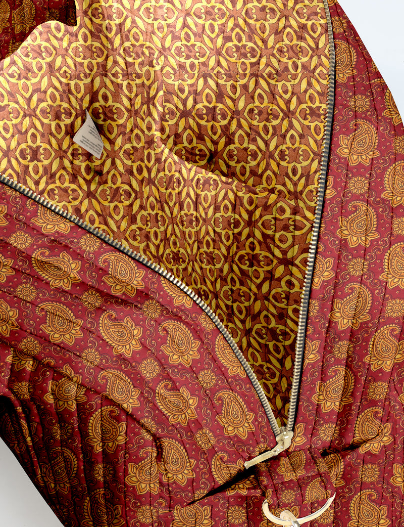 Brown quilted duffle bag with paisley pattern, front zip pocket, dual handles, and label reading "I was a sari"