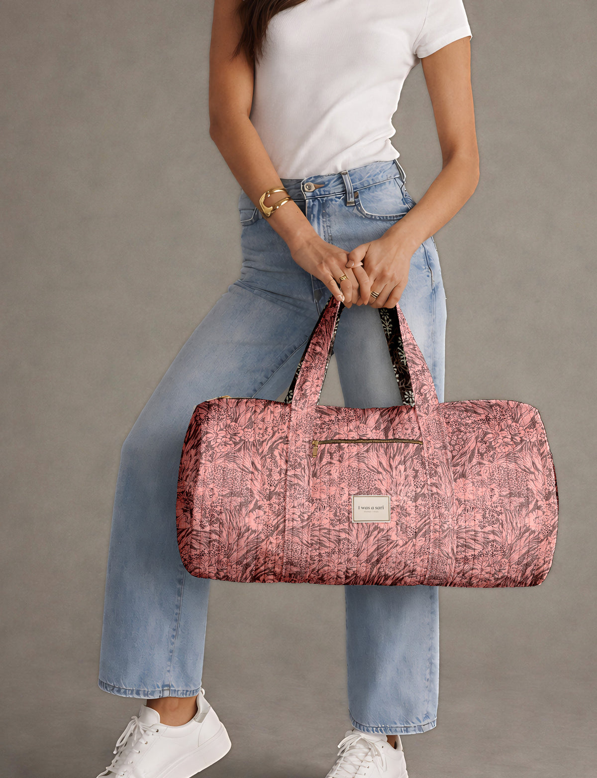 Brown paisley quilted bowling bag with dual handles, front zipper pocket, and "I was a sari" label on front side