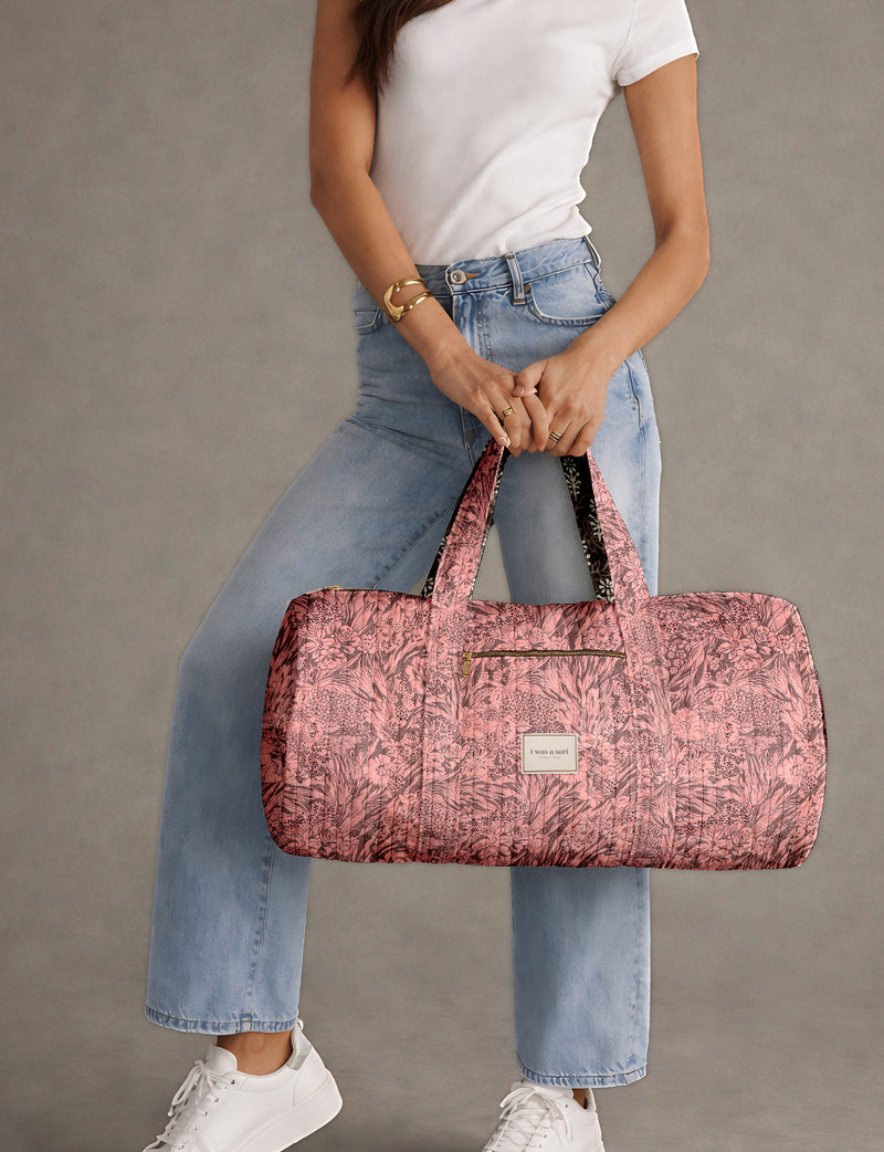 Brown paisley quilted bowling bag with dual handles, front zipper pocket, and "I was a sari" label on front side
