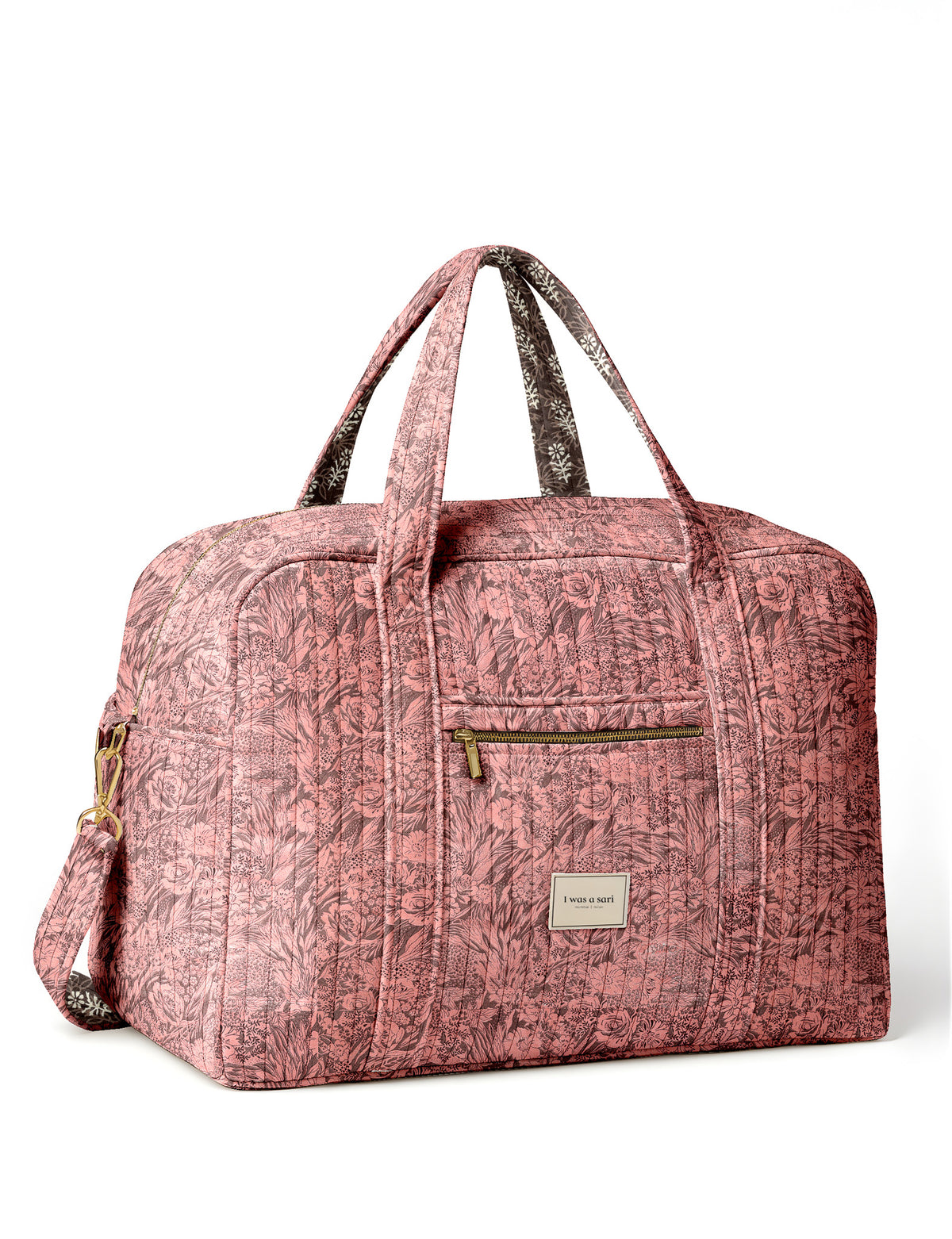 Brown quilted duffle bag with paisley pattern, front zip pocket, dual handles, and label reading "I was a sari"