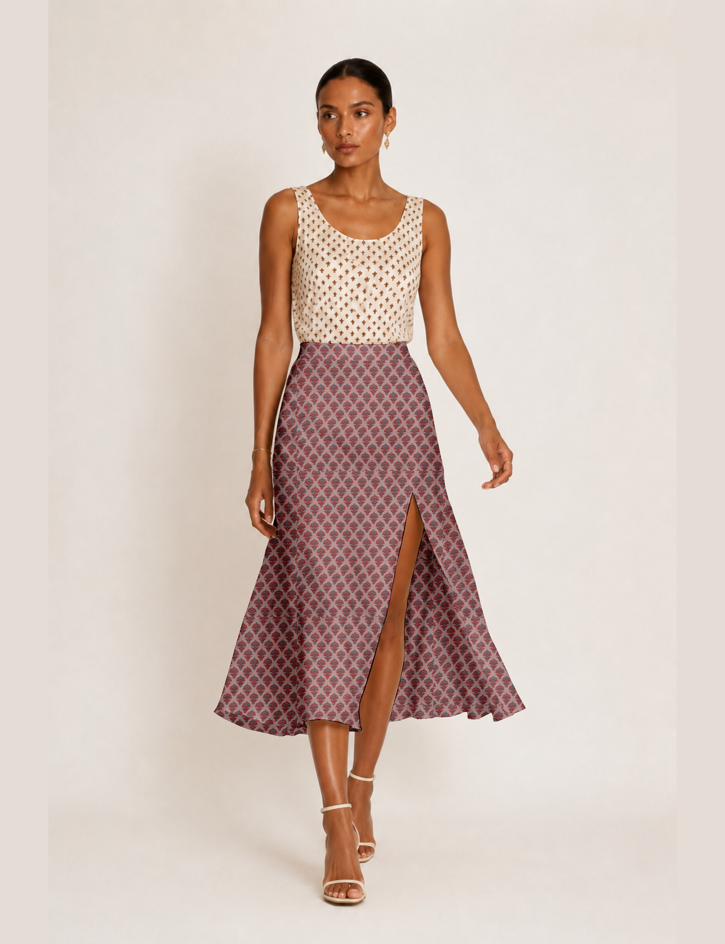 Woman wearing a yellow and black micro patterned A-line skirt with front slit, paired with beige sleeveless top and black