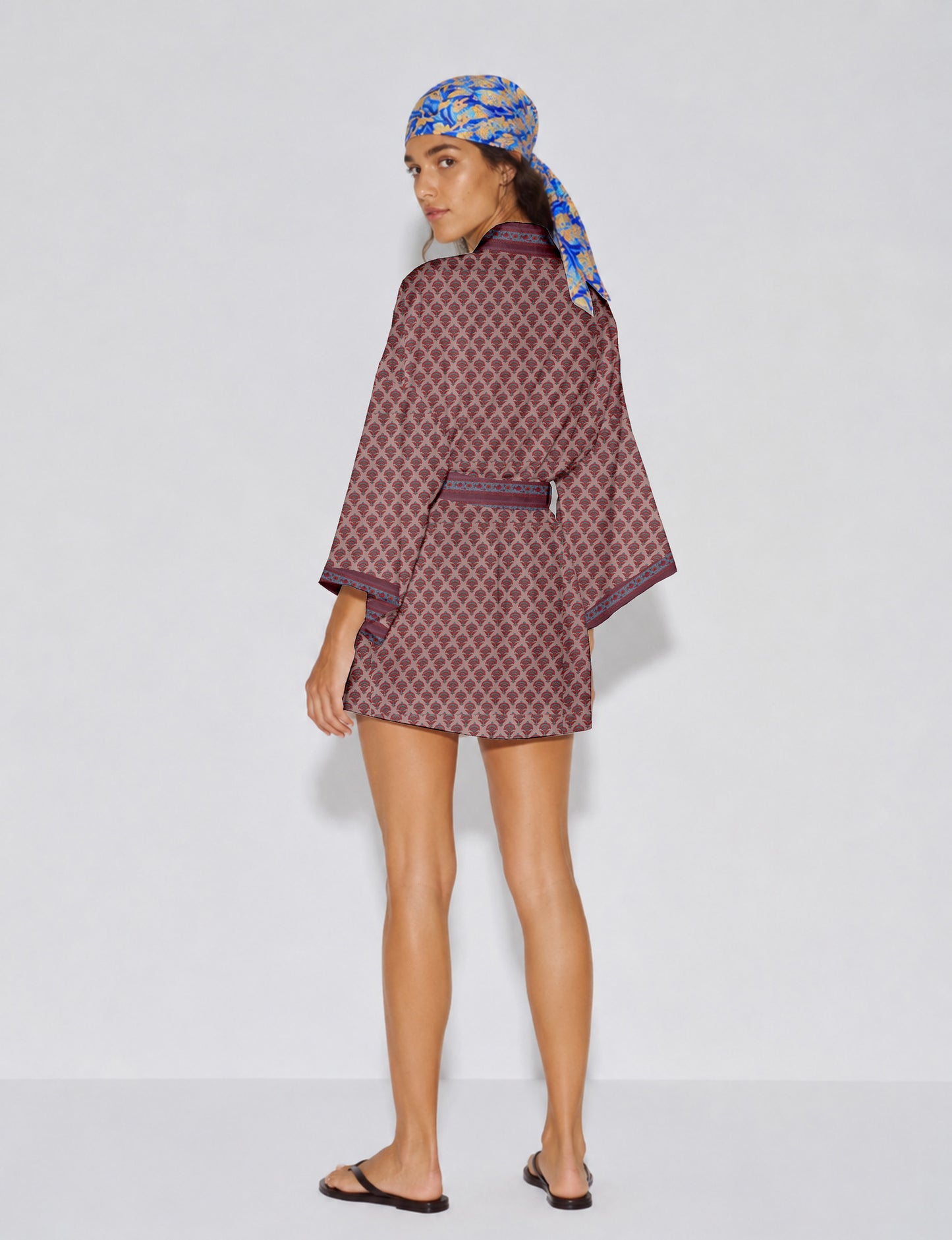 Short kimono robe with wrap front, V-neckline, wide sleeves, waist tie, and concealed skort detail.
