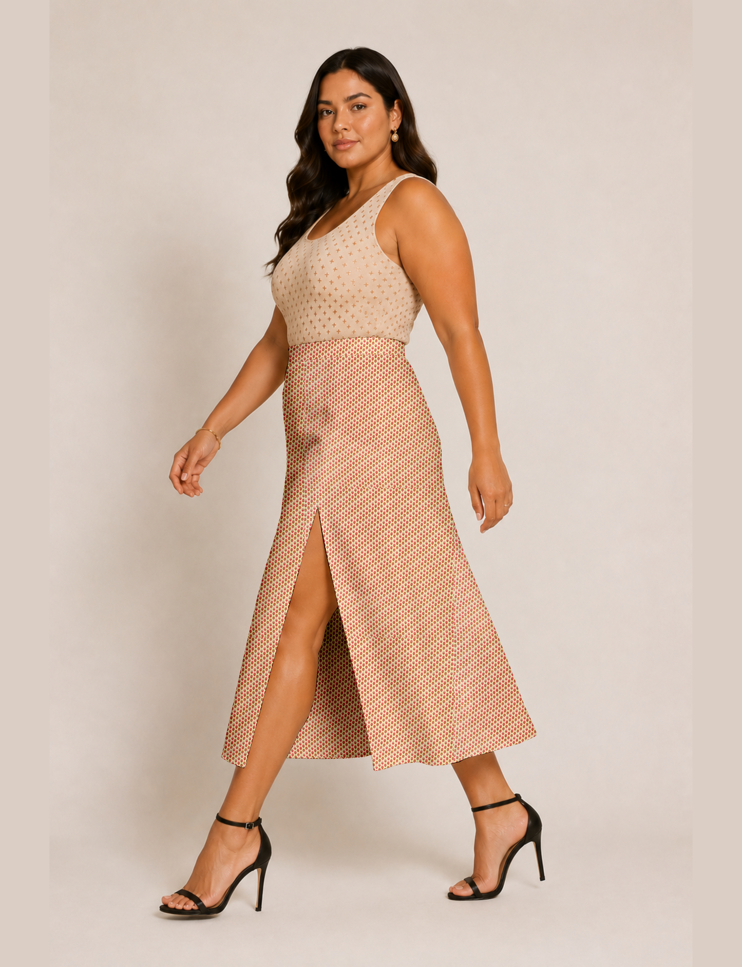 Woman wearing a yellow and black micro patterned A-line skirt with front slit, paired with beige sleeveless top and black