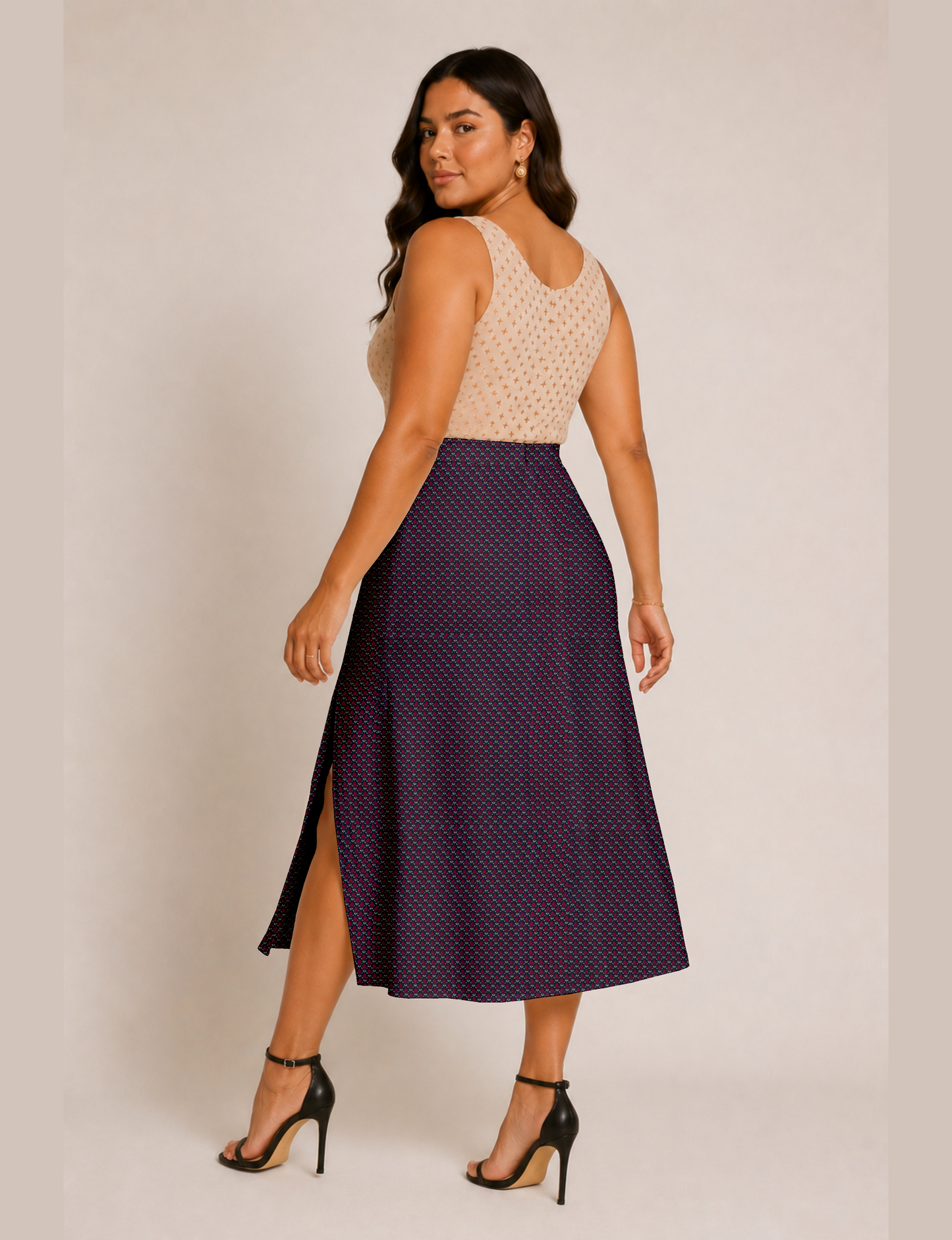 Woman wearing a yellow and black micro patterned A-line skirt with front slit, paired with beige sleeveless top and black